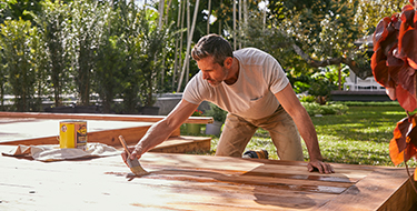 person staining a deck